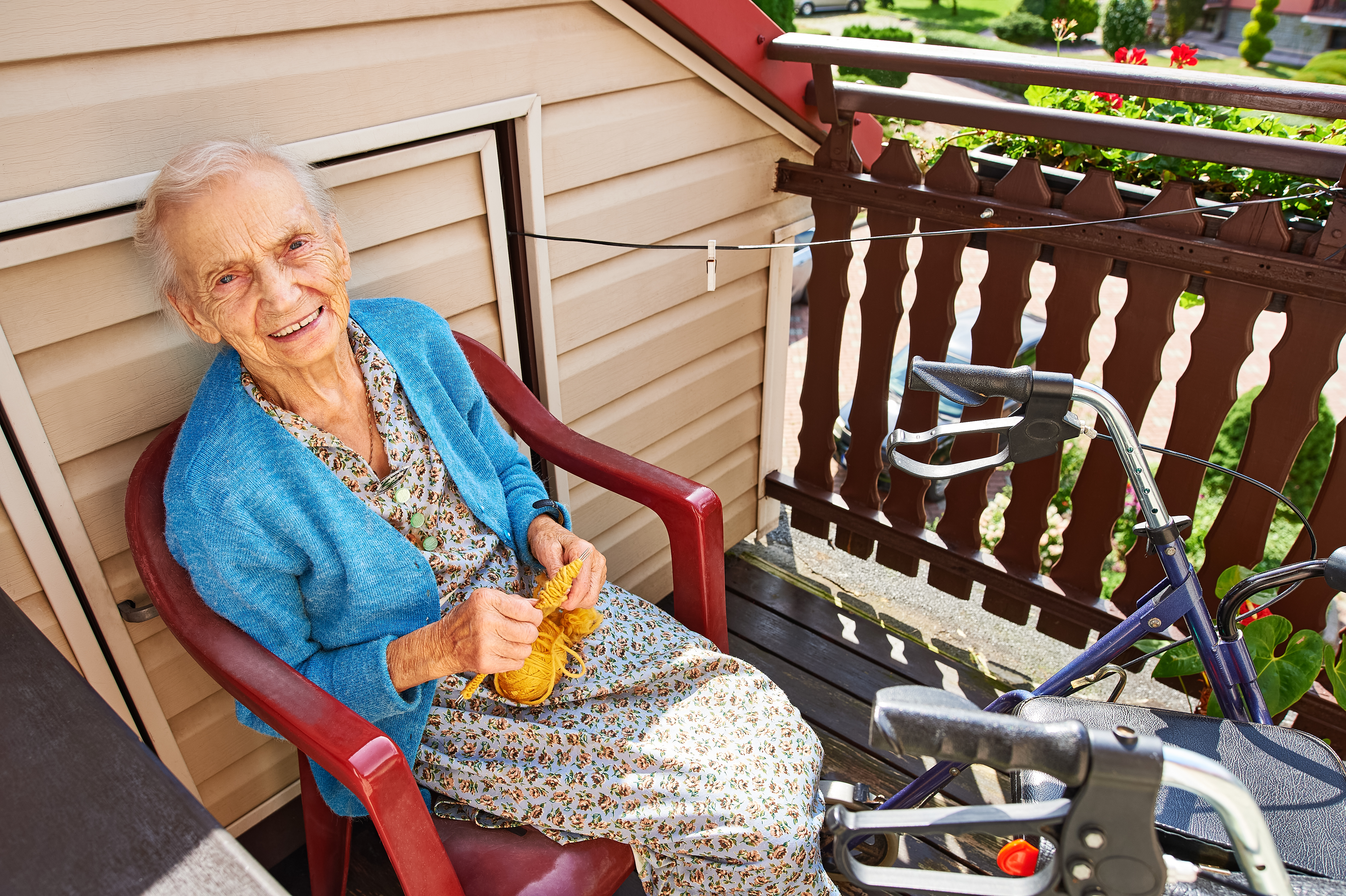 Uśmiechnięta Pani siedząca na krześle na balkonie