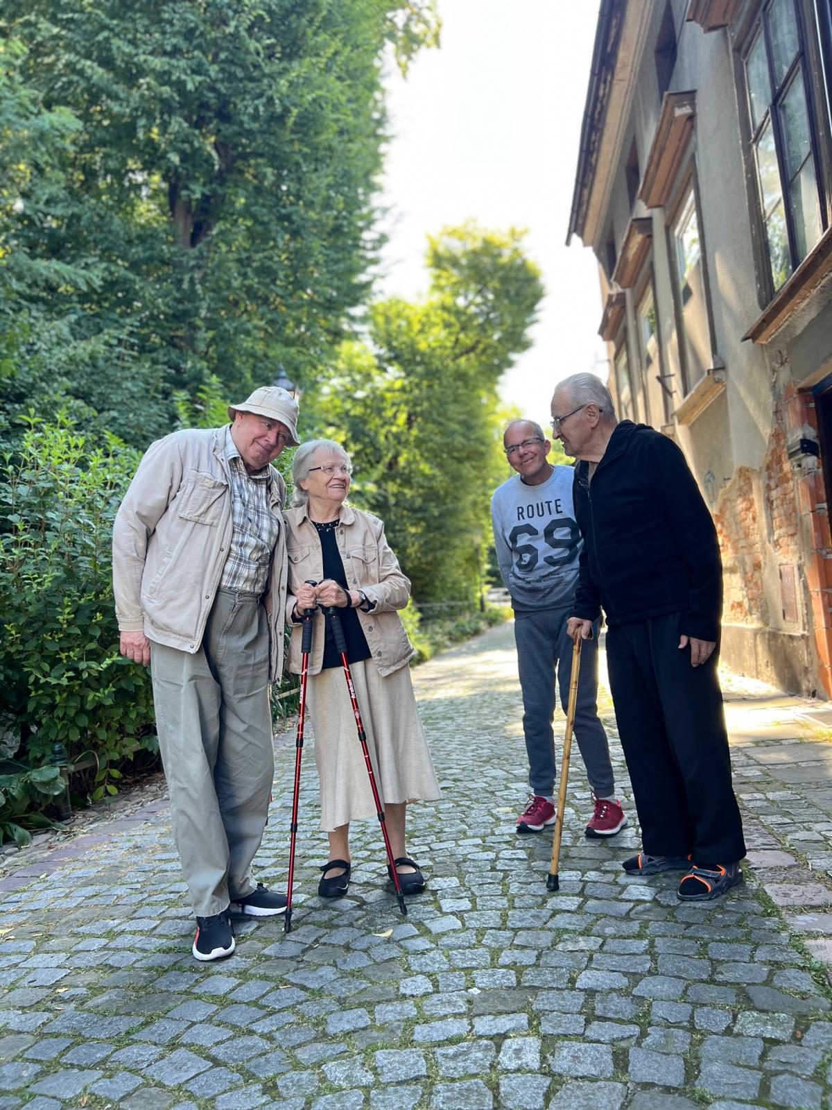 Grupa osób w wąskiej brukowanej uliczce