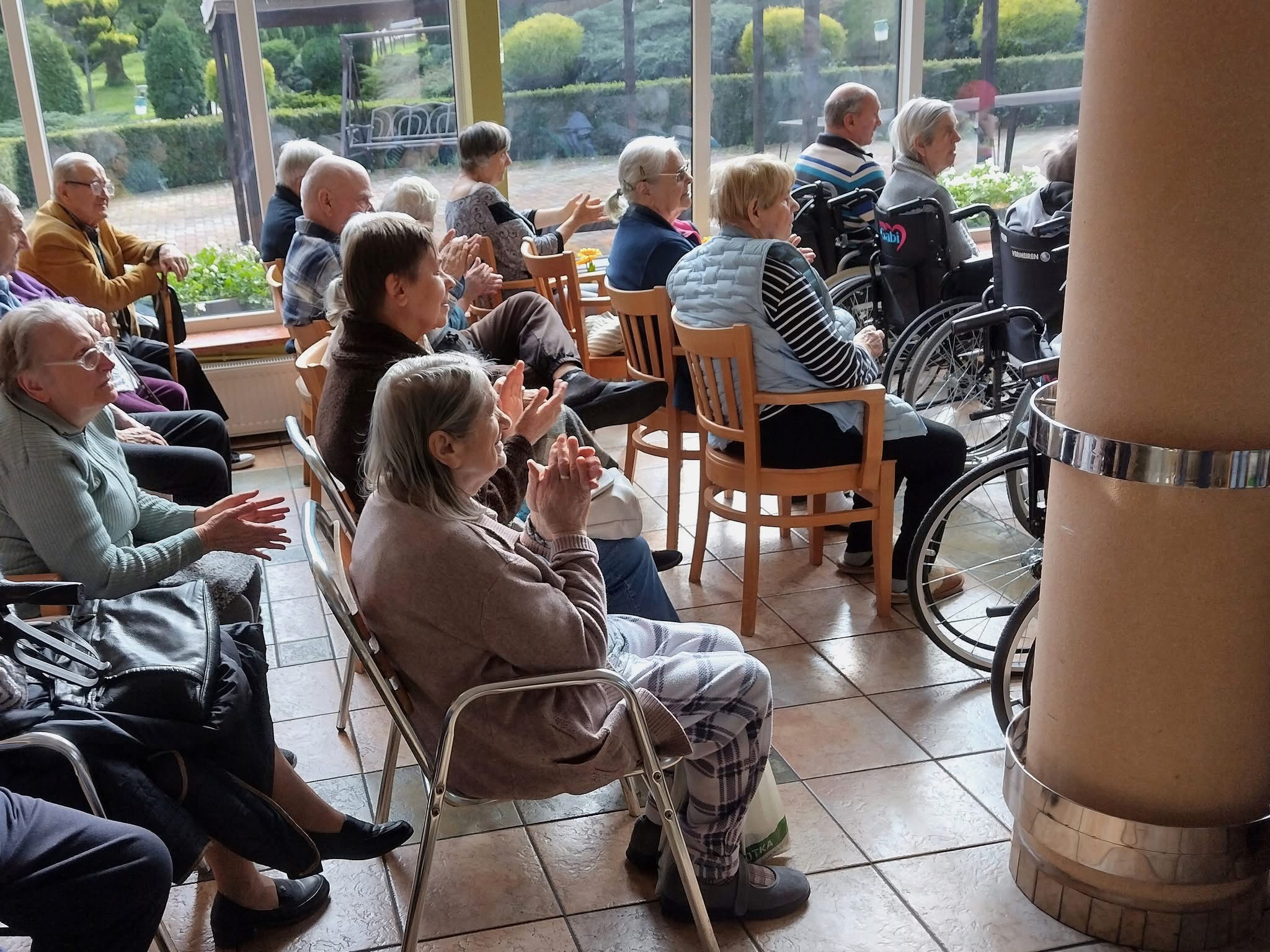 Seniorzy oklaskujący występ chóru