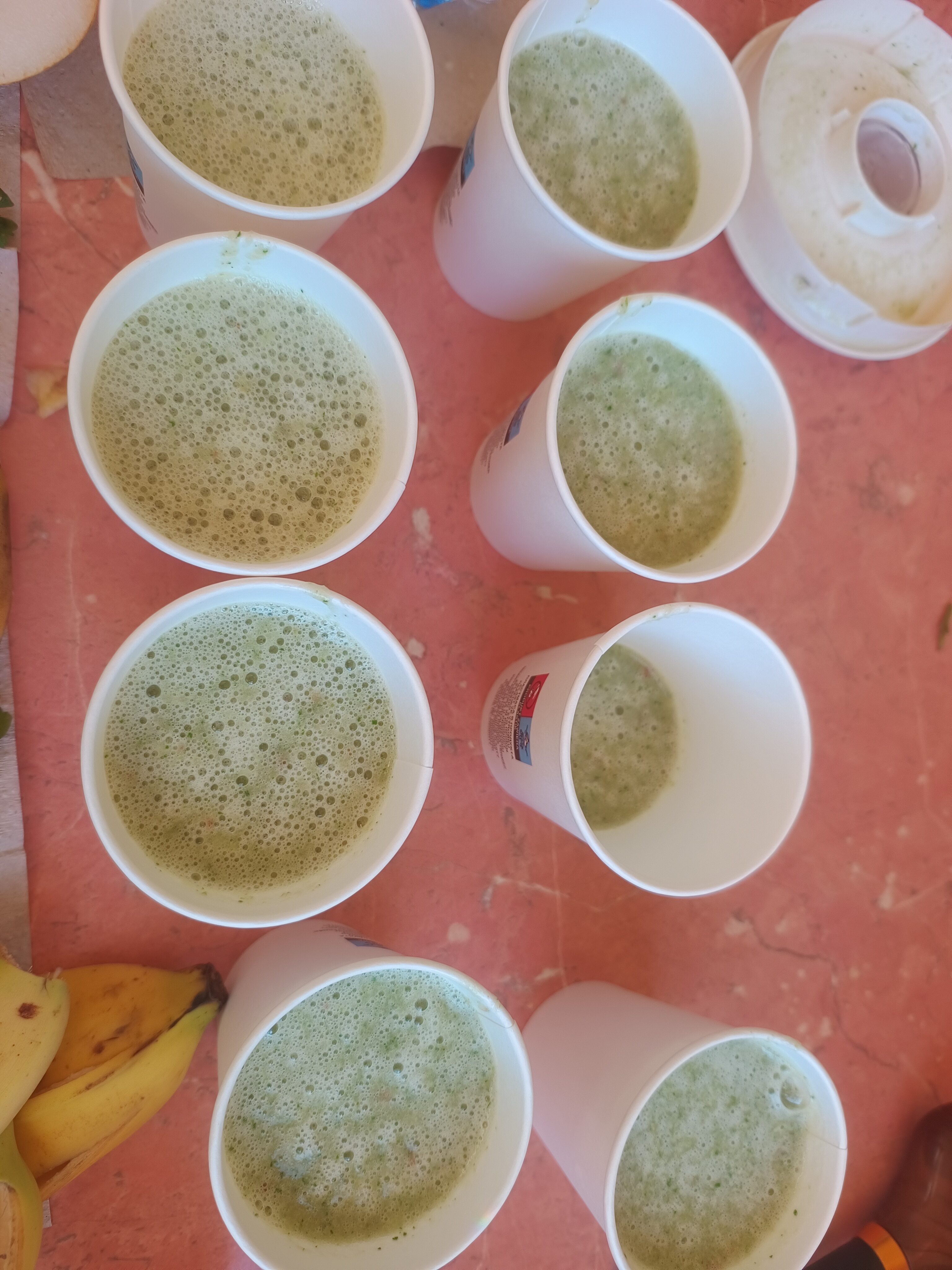 Papierowe kubki pełne koktajlu warzywno-owocowego