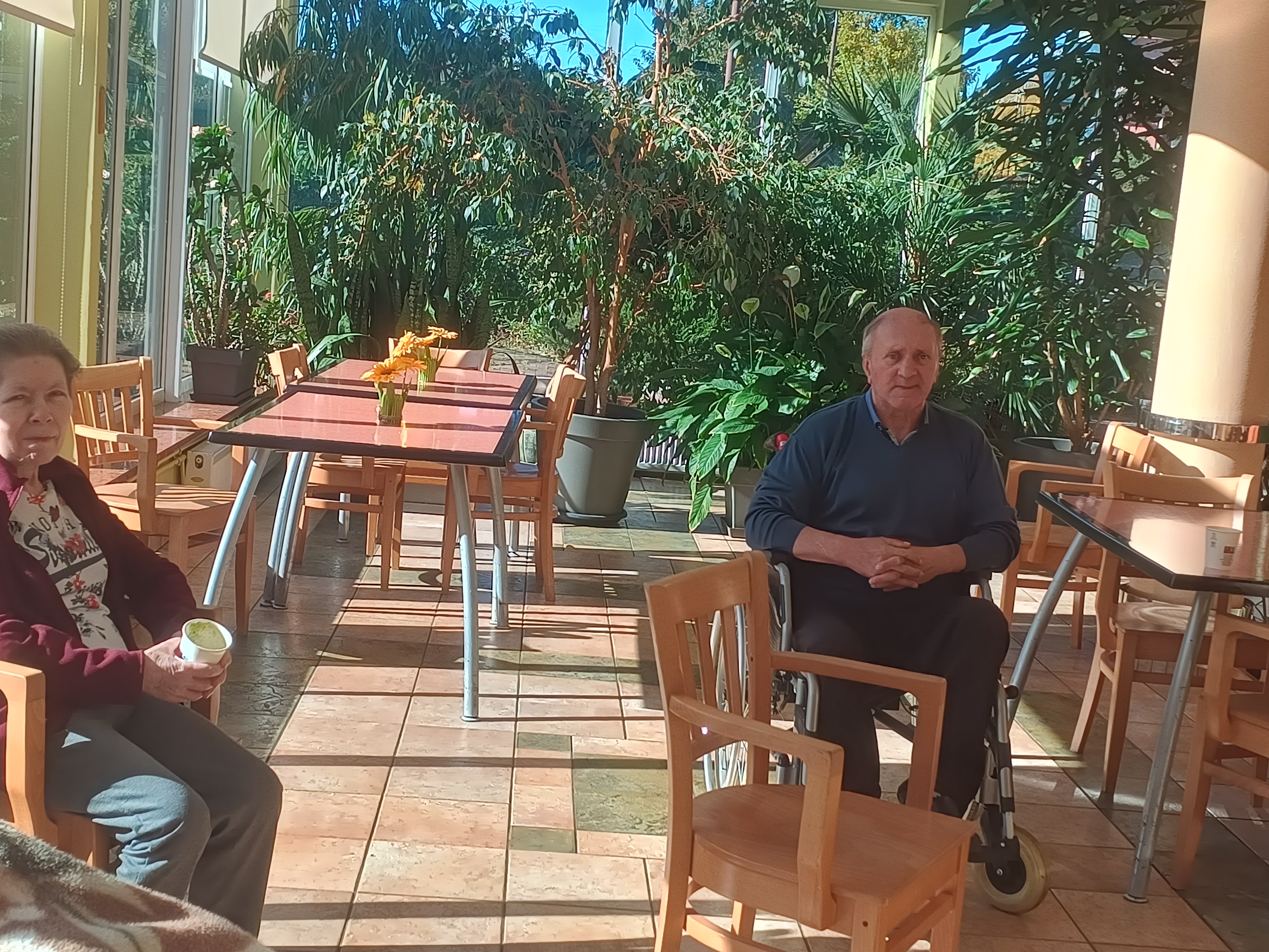 Seniorzy w ogrodzie zimowym oczekujący na degustację koktajlu