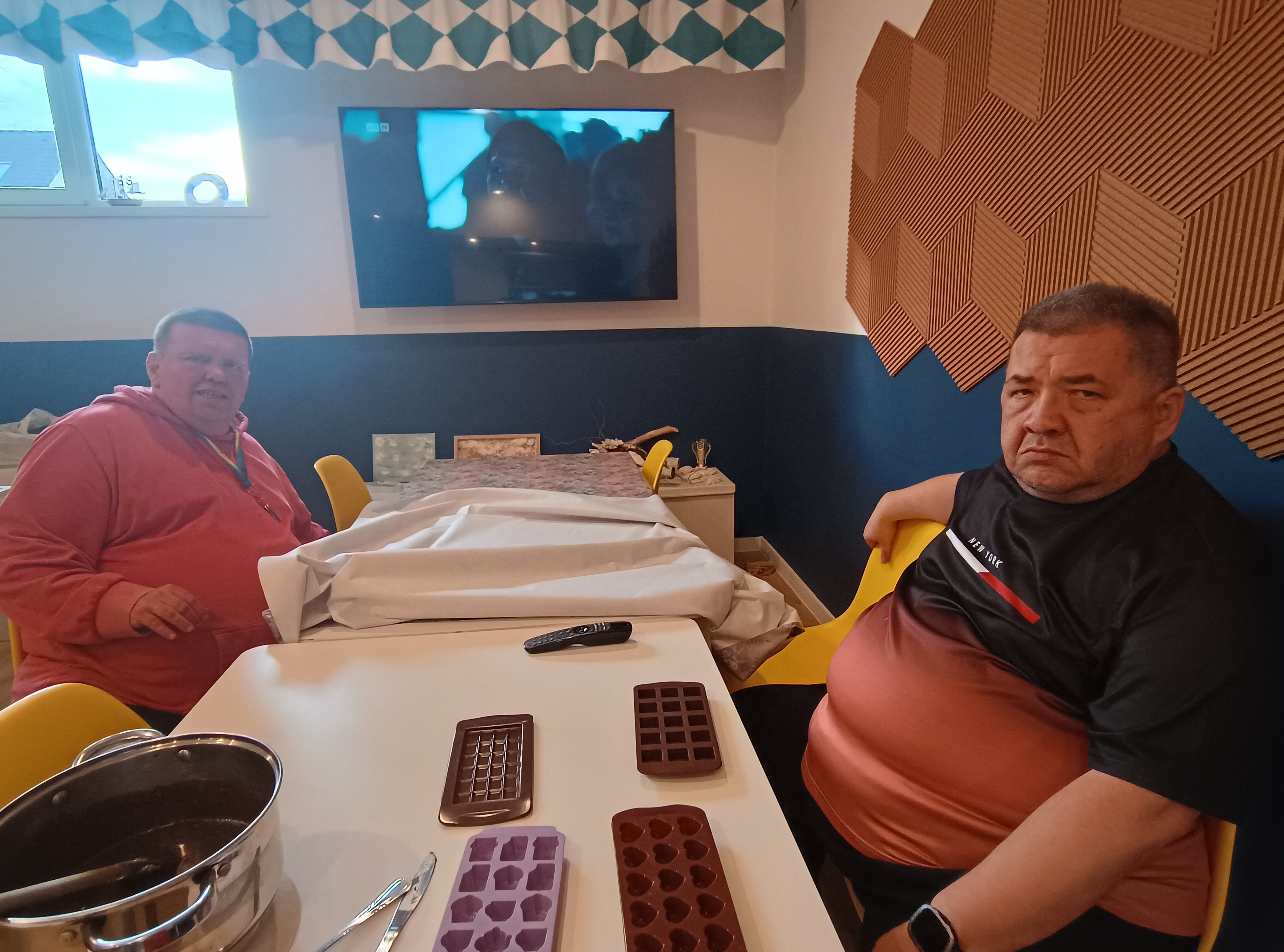 Panowie siedzą przy stole na którym są foremki do ciastek