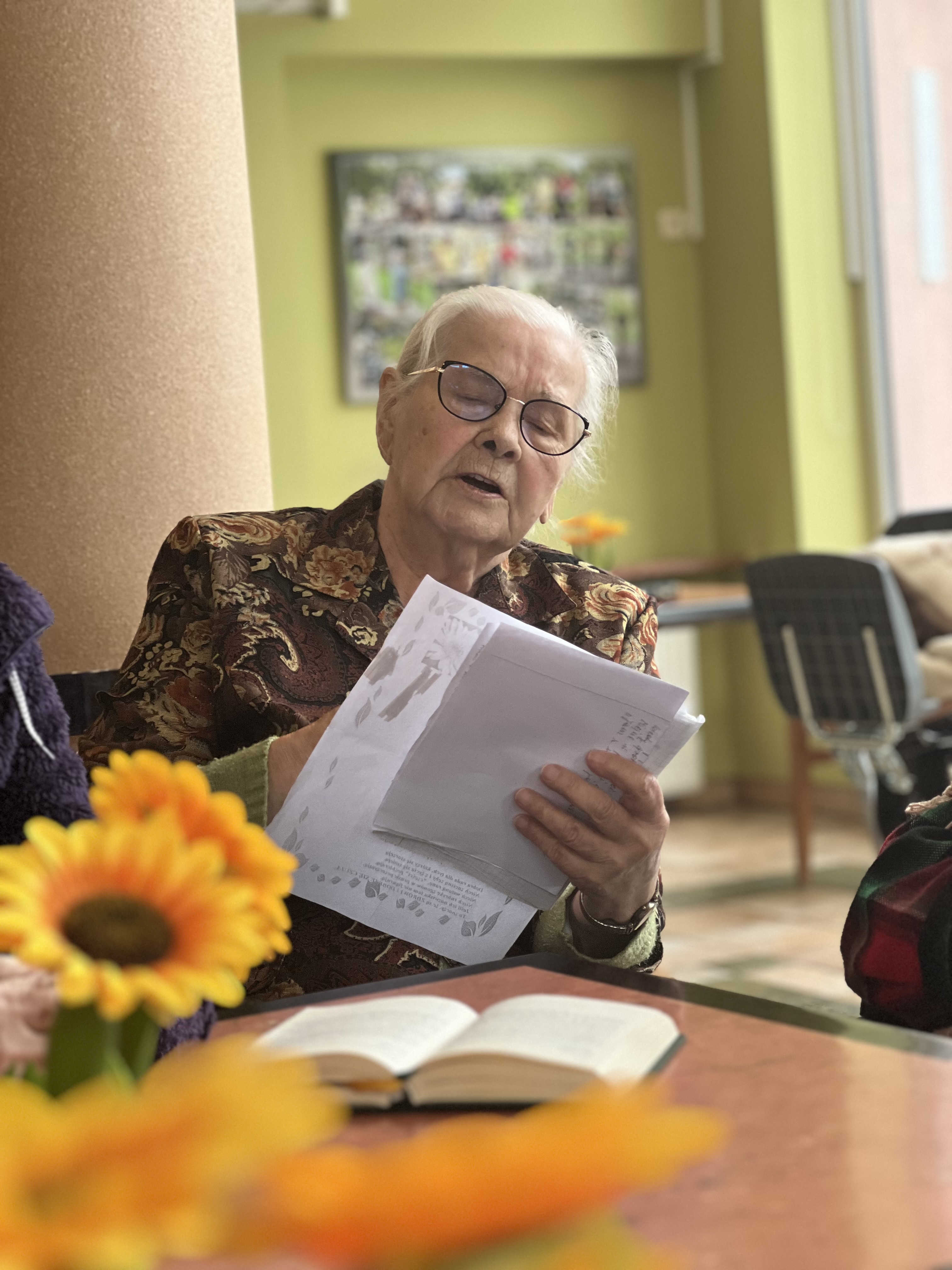 Seniorka wpatrzona w tekst pieśni