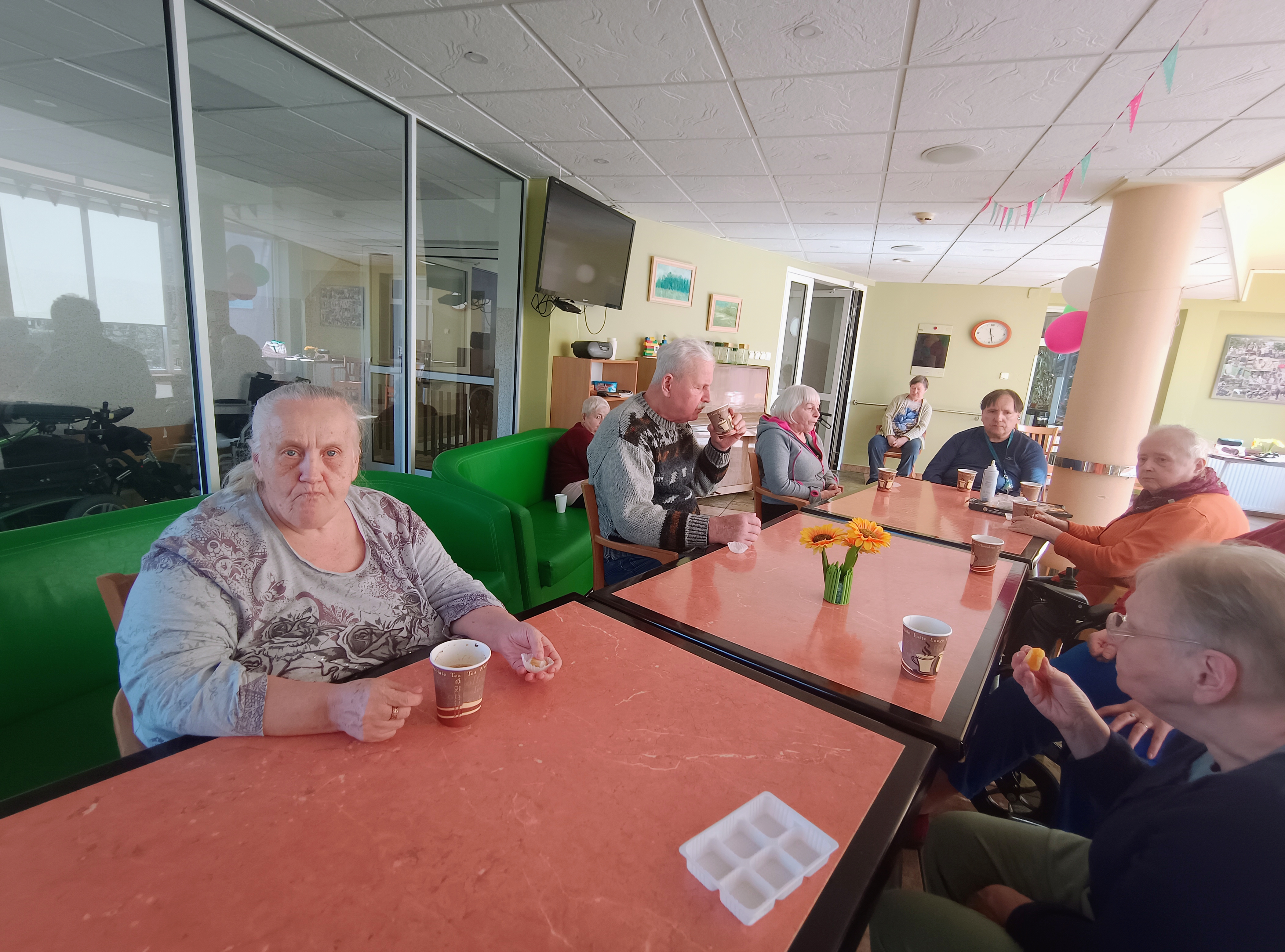 Seniorzy przy stolikach podczas degustacji