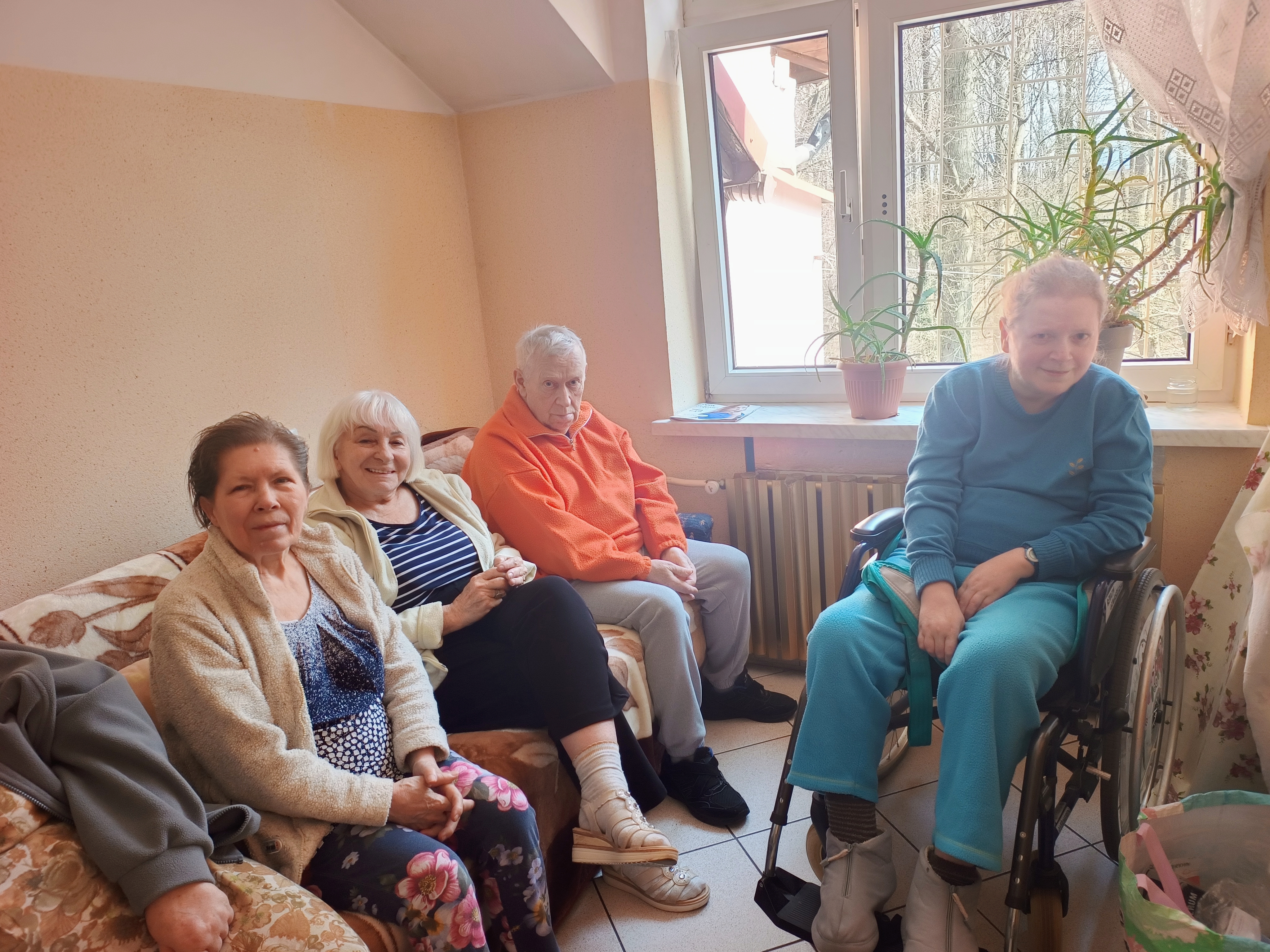 Grupa seniorów oczekuje na degustację własnoręcznie przygotowanych ciasteczek