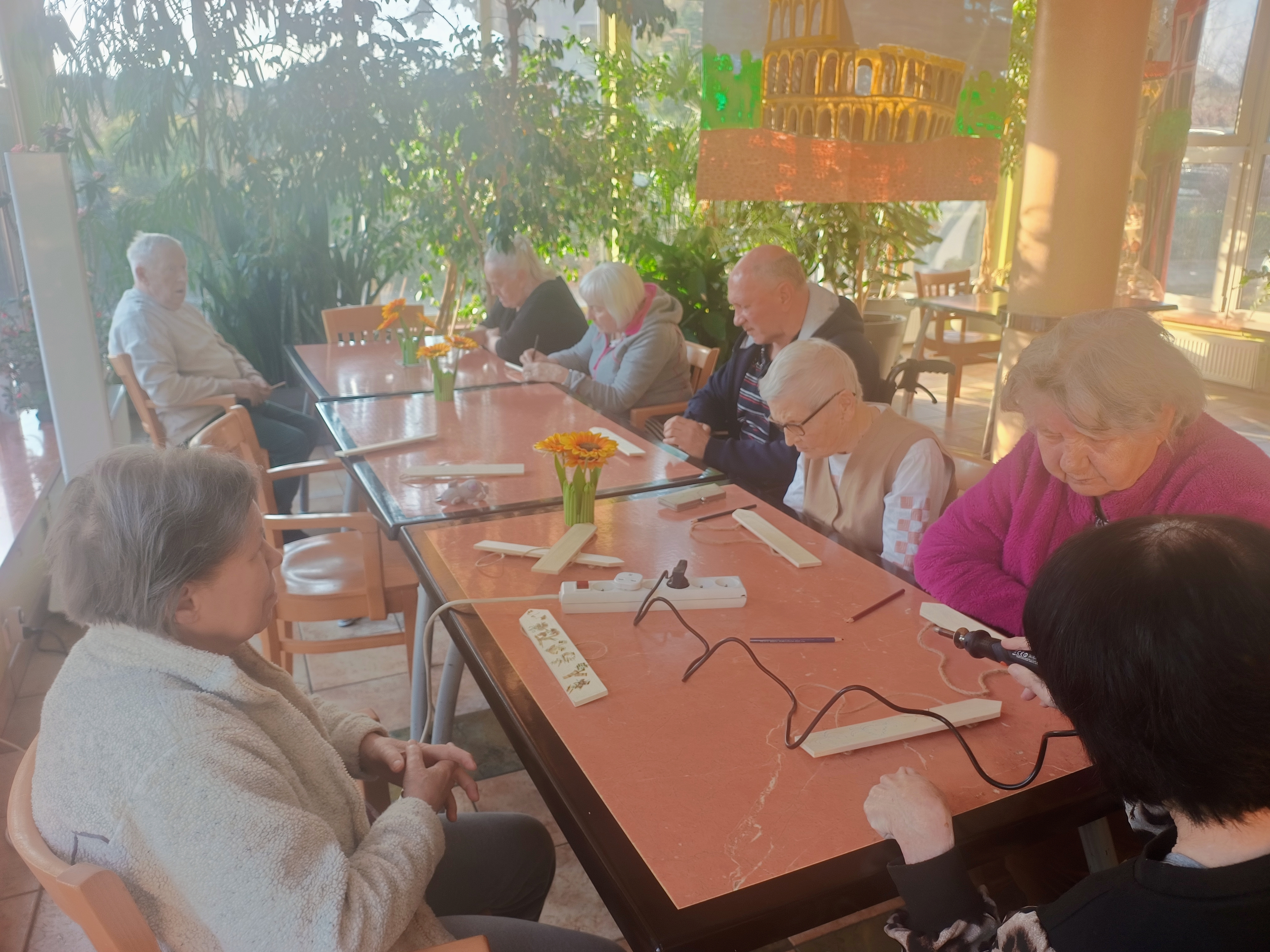 Seniorzy podczas prac - wypalanie na deseczkach